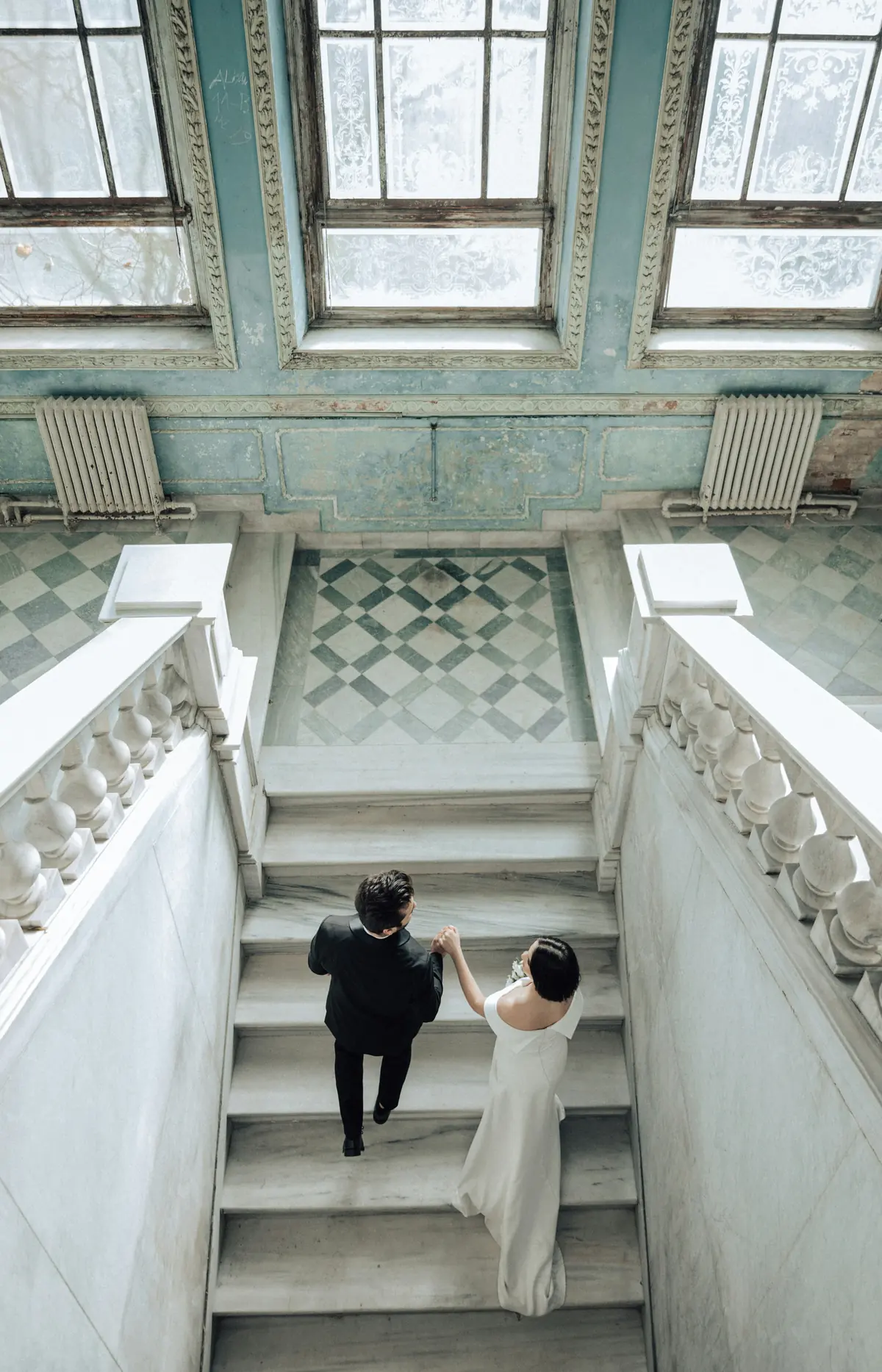 A couple climbing a stone staircase inside a historic house