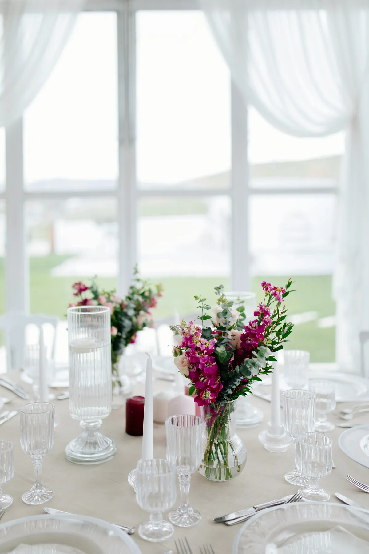 Round tables set inside a marquee with tall windows
